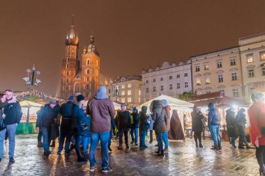 Krakow, Polonya - 3 Aralık 2017: Krakow, Polonya'daki St. Mary Bazilikası ile rynek Glowny adlı ortaçağ meydanında Noel pazarı tezgahları