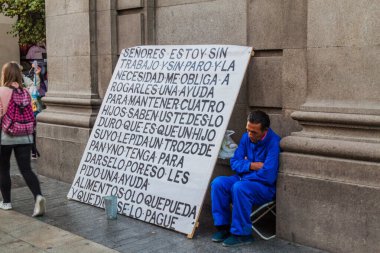 Madrid, İspanya - 25 Ekim 2017: Madrid 'in merkezinde büyük bir tabelası olan evsiz adam.