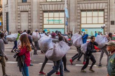 MADRID, SPAIN - OCTOBER 22, 2017: Street sellers runnig from police at Calle Gran Via street in Madrid. clipart