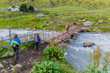 ALTYN ARASHAN, KYRGYZSTAN - 17 Temmuz 2018: Terskey Alatau dağ sırasındaki Arashan Nehri üzerindeki yaya köprüsü, Kırgızistan