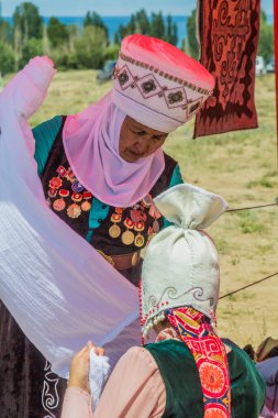 ISSYK KUL, KYRGYZSTAN - 15 Temmuz 2018: Kırgızistan 'daki Issyk Kul Gölü kıyısındaki Teskey Jeek Etnofestival' de geleneksel elbise giyen yerli kadınlar