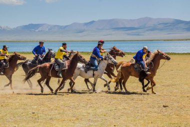 SONG KOL, KYRGYZSTAN - 25 Temmuz 2018: Yerel halk Son Kol Gölü kıyılarında düzenlenen Ulusal At Oyunları Festivali 'nde bir keçi leşi ile geleneksel bir at oyunu olan kok boru (ulak tartysh) oynuyor.