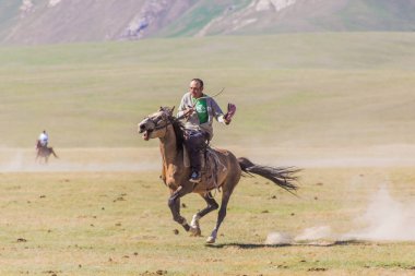 Song KOL, KYRGYZSTAN - 25 Temmuz 2018 Kırgızistan 'ın Son Kol Gölü kıyılarında at binicileri
