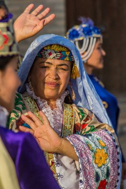 BÜKHARA, UZBEKISTAN - 30 Nisan 2018: Buhara, Özbekistan 'ın merkezinde geleneksel elbise giyen dansçı
