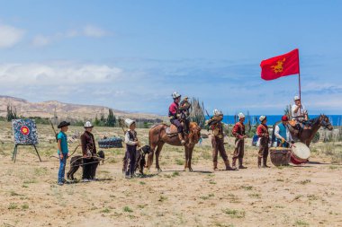 ISSYK KUL, KYRGYZSTAN - 15 Temmuz 2018: Kırgızistan 'daki Issyk Kul Gölü kıyısındaki Teskey Jeek Etnofestivali yerel okçuları. Tarihi bayrak