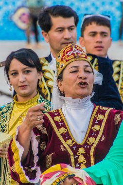 BÜKHARA, UZBEKISTAN - 30 Nisan 2018: Buhara, Özbekistan 'ın merkezinde geleneksel elbiseler giyen dansçılar