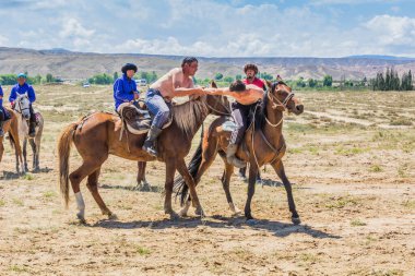 ISSYK KUL, KYRGYZSTAN - 15 Temmuz 2018: Kırgızistan 'daki Issyk Kul Gölü kıyısındaki Teskey Jeek Etnofestival' de at güreşi