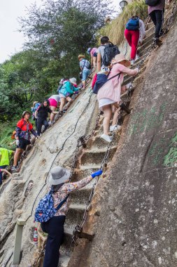 HUA ŞAN, ÇİN - 4 AĞUSTOS 2018: İnsanlar Çin 'in Şanksi ilindeki Hua Shan dağının zirvelerine çıkan merdivenlere tırmanıyor