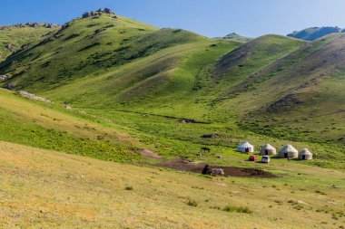 Kırgızistan 'daki Song Kul Gölü yakınlarındaki dağlarda yurt kampı.