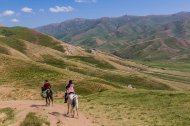 Song Kul Gölü yakınlarındaki dağlarda at binicileri, Kırgızistan