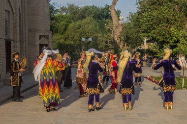 BÜKHARA, UZBEKISTAN - 30 Nisan 2018: Buhara, Özbekistan 'ın merkezinde geleneksel elbiseler giyen dansçılar