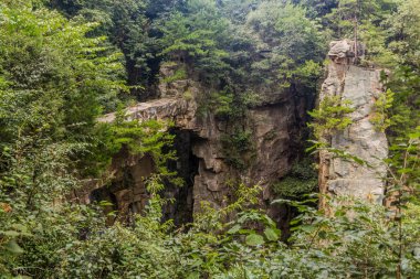 Çin 'in Hunan eyaletindeki Zhangjiajie Ulusal Orman Parkı' ndaki Wulingyuan Manzarası ve Tarihi İlgi Alanı 'ndaki kaya köprüsü.