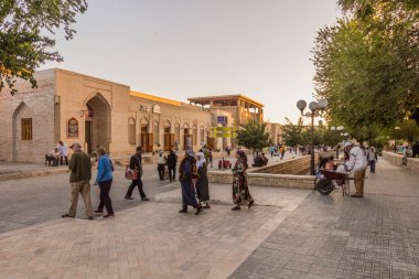 BÜKHARA, UZBEKISTAN - 1 Mayıs 2018: İnsanlar Özbekistan 'ın Buhara kentindeki Bakhowuddin Nakshbandi Caddesi boyunca yürüyor