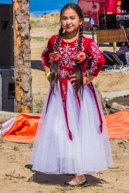 ISSYK KUL, KYRGYZSTAN - 15 Temmuz 2018: Kırgızistan 'daki Issyk Kul Gölü kıyısındaki Teskey Jeek Etnofestival' de geleneksel elbise giyen kız