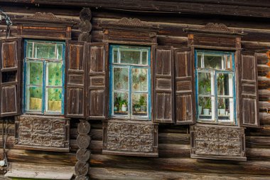 Rusya 'nın Tyumen şehrindeki tipik eski Rus ahşap evinin pencereleri.