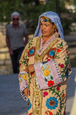 BÜKHARA, UZBEKISTAN - 30 Nisan 2018: Buhara, Özbekistan 'ın merkezinde geleneksel elbise giyen yerli kadın