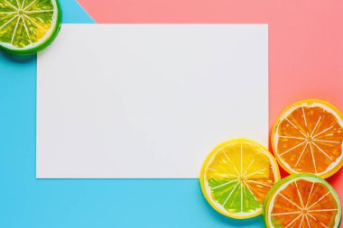 Limon dilimleri pembe ve mavi pastel renk arka plan üzerinde beyaz kağıt çerçeveli
