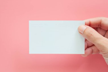 Pembe arka plan boş kartvizit tutan el