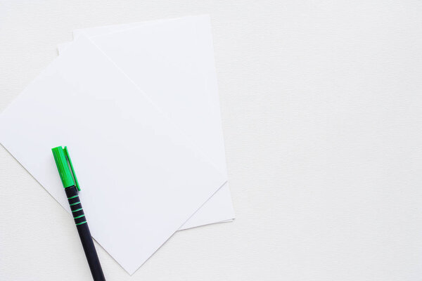 Простая бумажная карточка с ручкой на белом фоне для концепции рабочего пространства
