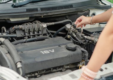 Kadın eli araç ve ulaşım konsepti için araba motoru yolculuk öncesi kontrol