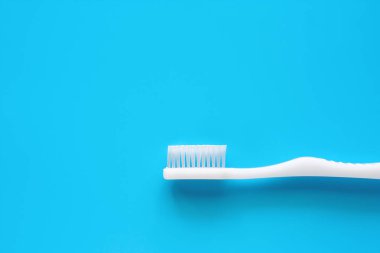 Beyaz diş fırçası diş bakımı konsepti için mavi arka plan üzerinde diş temizliğinde kullanılan