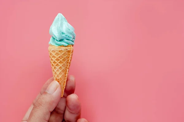 手拿冰淇淋锥粉红色的背景甜蜜和清爽的甜点概念 — 图库照片