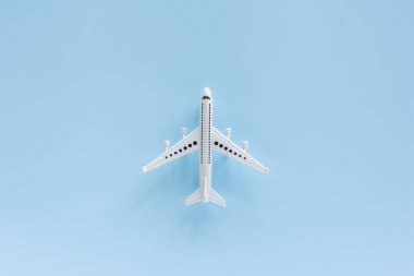 Araç ve ulaşım konsepti için mavi arka plan üzerinde beyaz uçak modeli