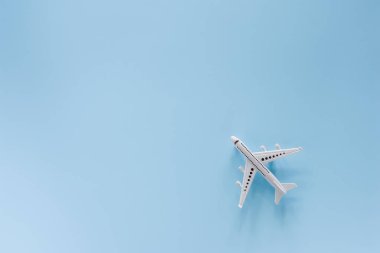 Araç ve ulaşım konsepti için mavi arka plan üzerinde beyaz uçak modeli