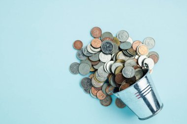 Yatırım, iş, finans ve tasarruf konsepti için mavi arka planda bir teneke kovada para dolu. 