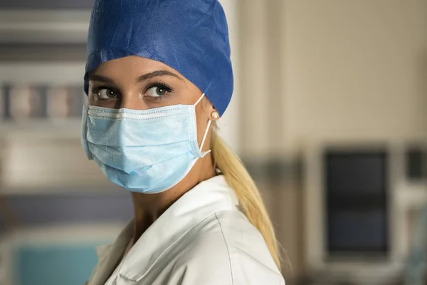 Junge Blonde Krankenschwester Zimmer Mit Maske Und Mütze lizenzfreie Stockfotos