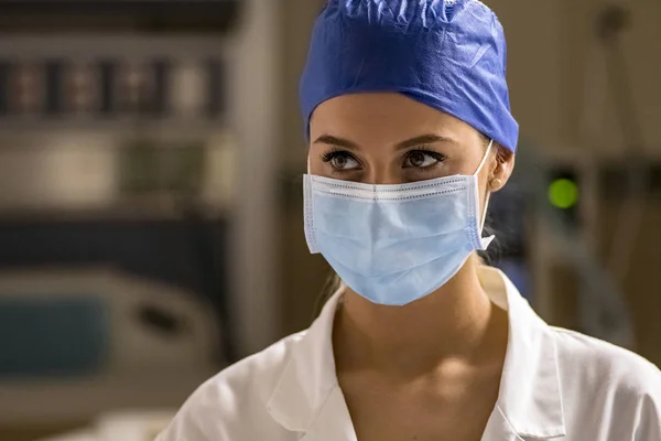 Genç sarışın hemşire acil odasında bir ameliyat maskesi ve cerrahi kap