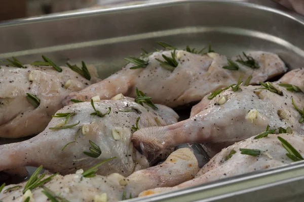 Biberiye ve metal tepsi sarımsak ile doldurulmuş ham ördek bacaklar