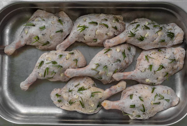 Biberiye ve metal tepsi sarımsak ile doldurulmuş ham ördek bacaklar