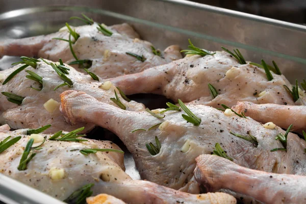 Biberiye ve metal tepsi sarımsak ile doldurulmuş ham ördek bacaklar