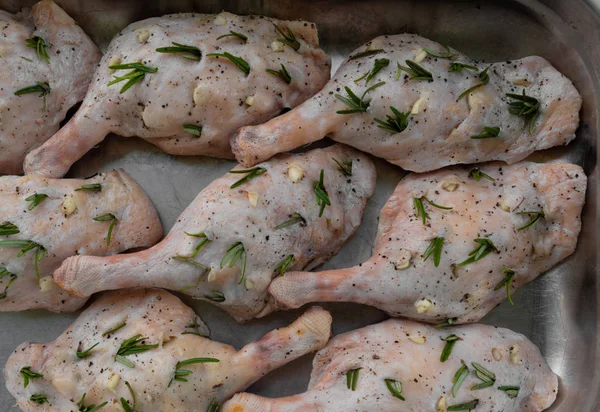 Biberiye ve metal tepsi sarımsak ile doldurulmuş ham ördek bacaklar