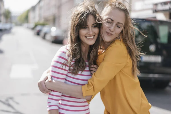Two Happy Girlfriends Embracing City — Stock Photo, Image