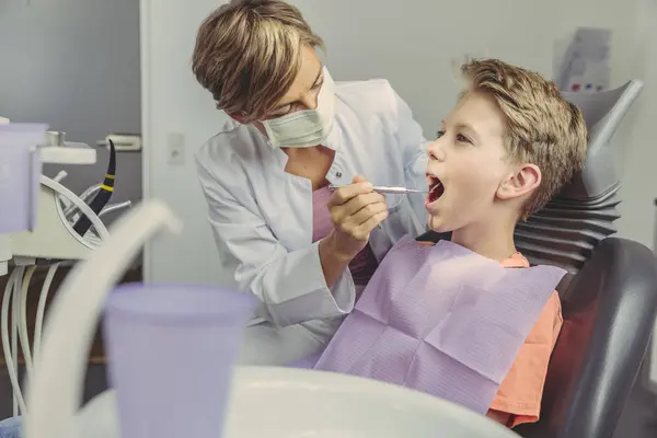 Diş Hekimi Diş Aletleriyle Çocuğun Dişlerini Inceliyor — Stok fotoğraf