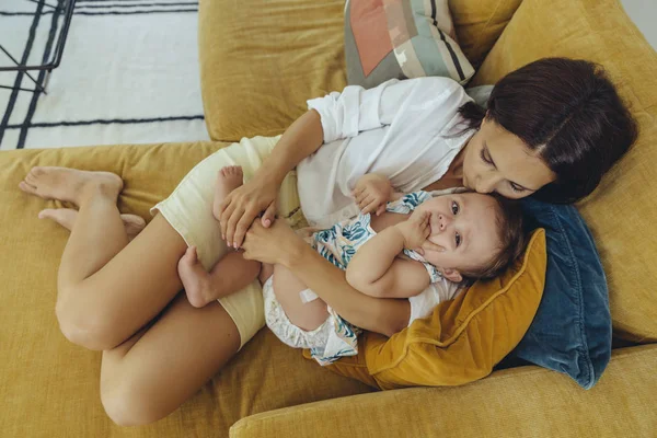 Mother Cuddling Kissing Her Baby Girl Couch — Stock Photo, Image