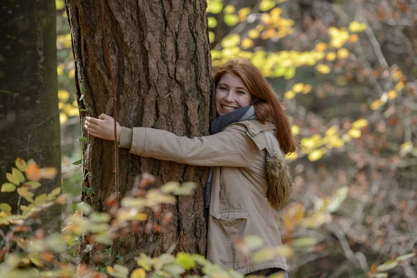 Porträtt Happy Teenage Girl Kramas Trädstam Höstlig Skog — Stockfoto
