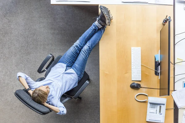 在办公室的办公桌上 在椅子上放松的女人的顶视图 — 图库照片