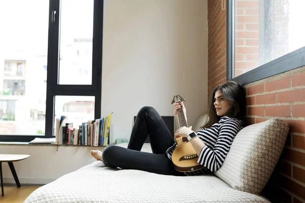 Jovem Mulher Sentada Sofá Casa Tocando Guitarra — Fotografia de Stock