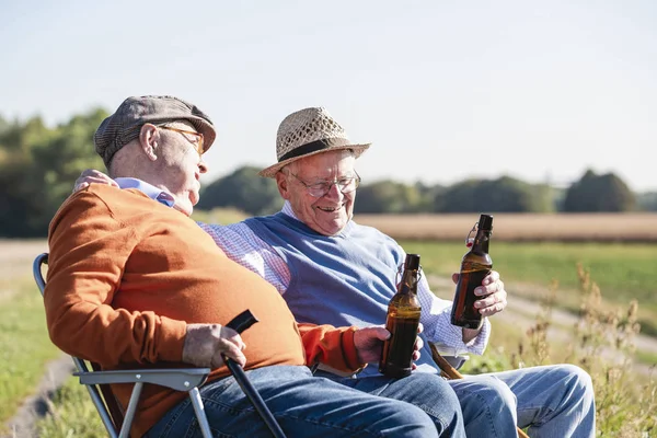 Dos Viejos Amigos Sentados Campo Bebiendo Cerveza Hablando Los Viejos —  Fotos de Stock