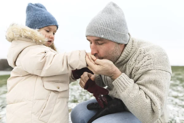 Отец Согревает Холодные Руки Дочери Зимой — стоковое фото