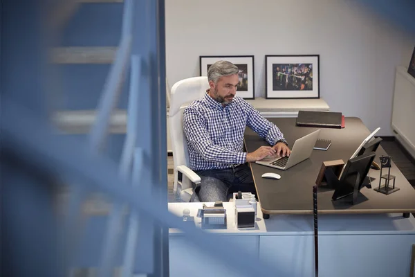 Empresário sentado no escritório trabalhando no laptop — Fotografia de Stock