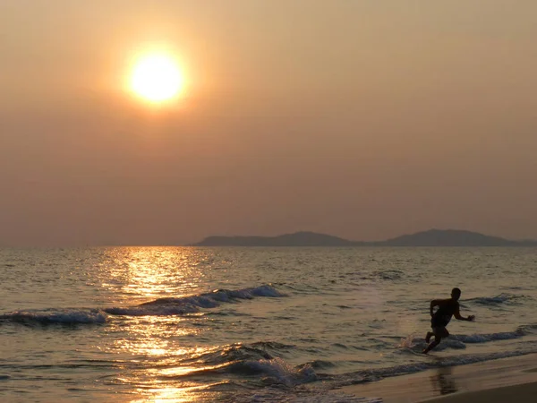 gün batımında sahilde çalışan çocuk
