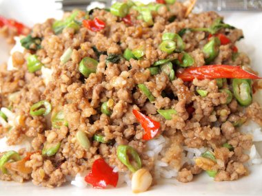 Pirinç karıştırın kızarmış domuz eti ve fesleğen ile tepesinde kapatın