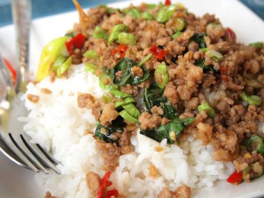 Pirinç karıştırın kızarmış domuz eti ve fesleğen ile tepesinde kapatın