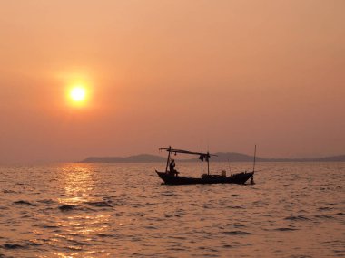 Balıkçı teknesi ve deniz üzerinde güzel gün batımı