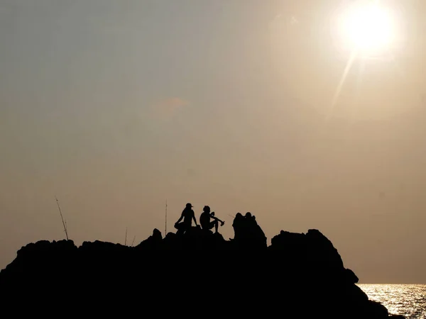 Ludzi Siedzi Klifie Nad Morze Zachody Słońca — Zdjęcie stockowe