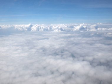 Mavi gökyüzü bulutlu, uçak penceresinden bir görünüm